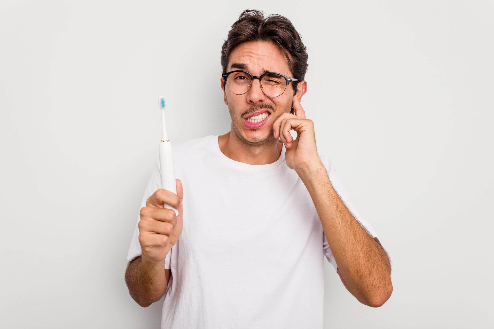 Guy holding tooth brush while pondering