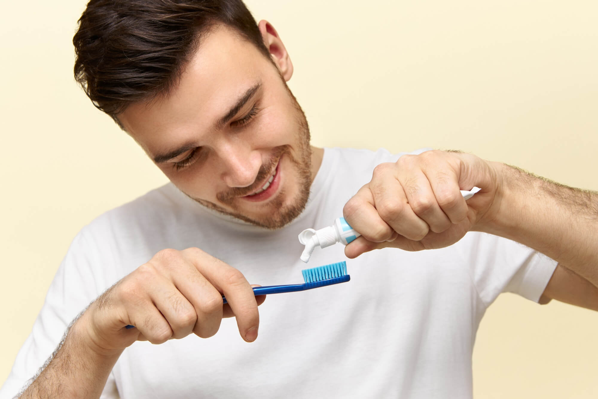Man putting toothpaste on toothbrush
