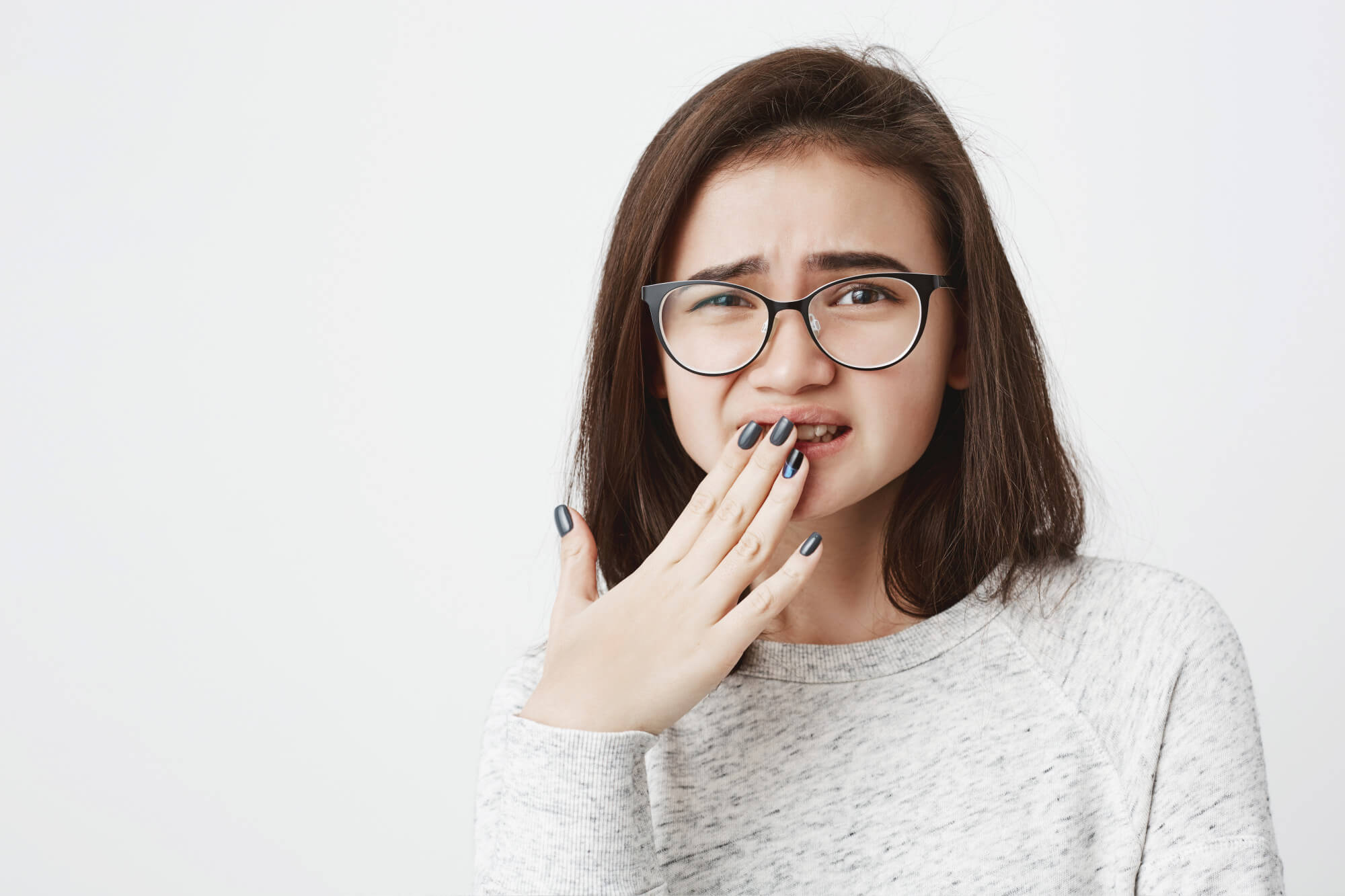 Young woman holding teeth in pain